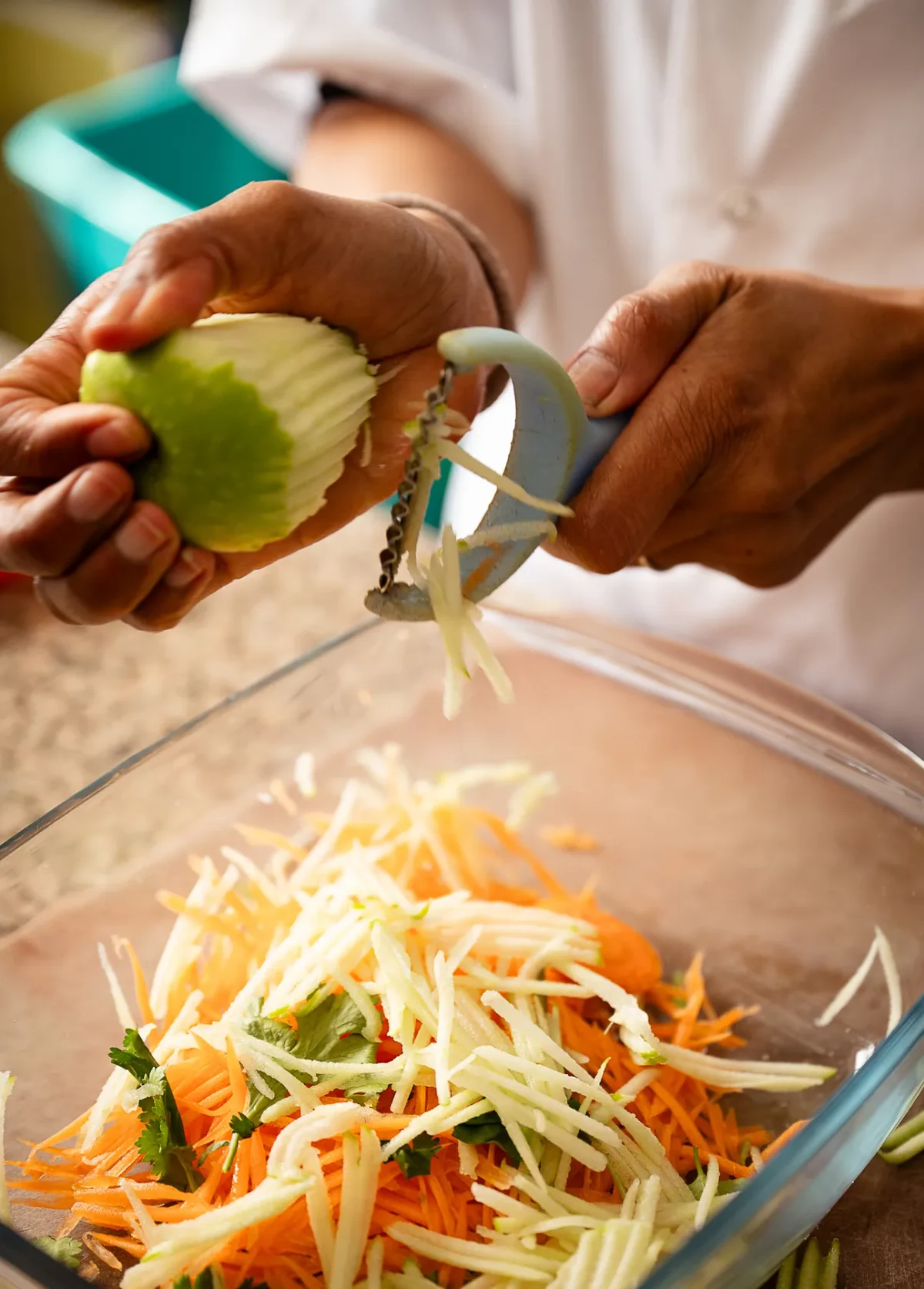 Fresh vegetables being shredded for a Thai salad