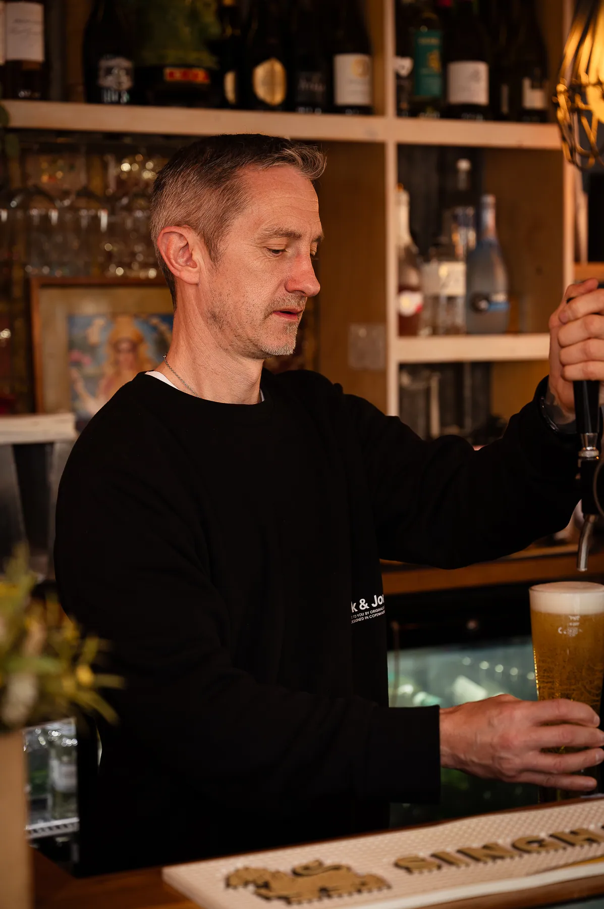 A draught beer being poured behind the bar
