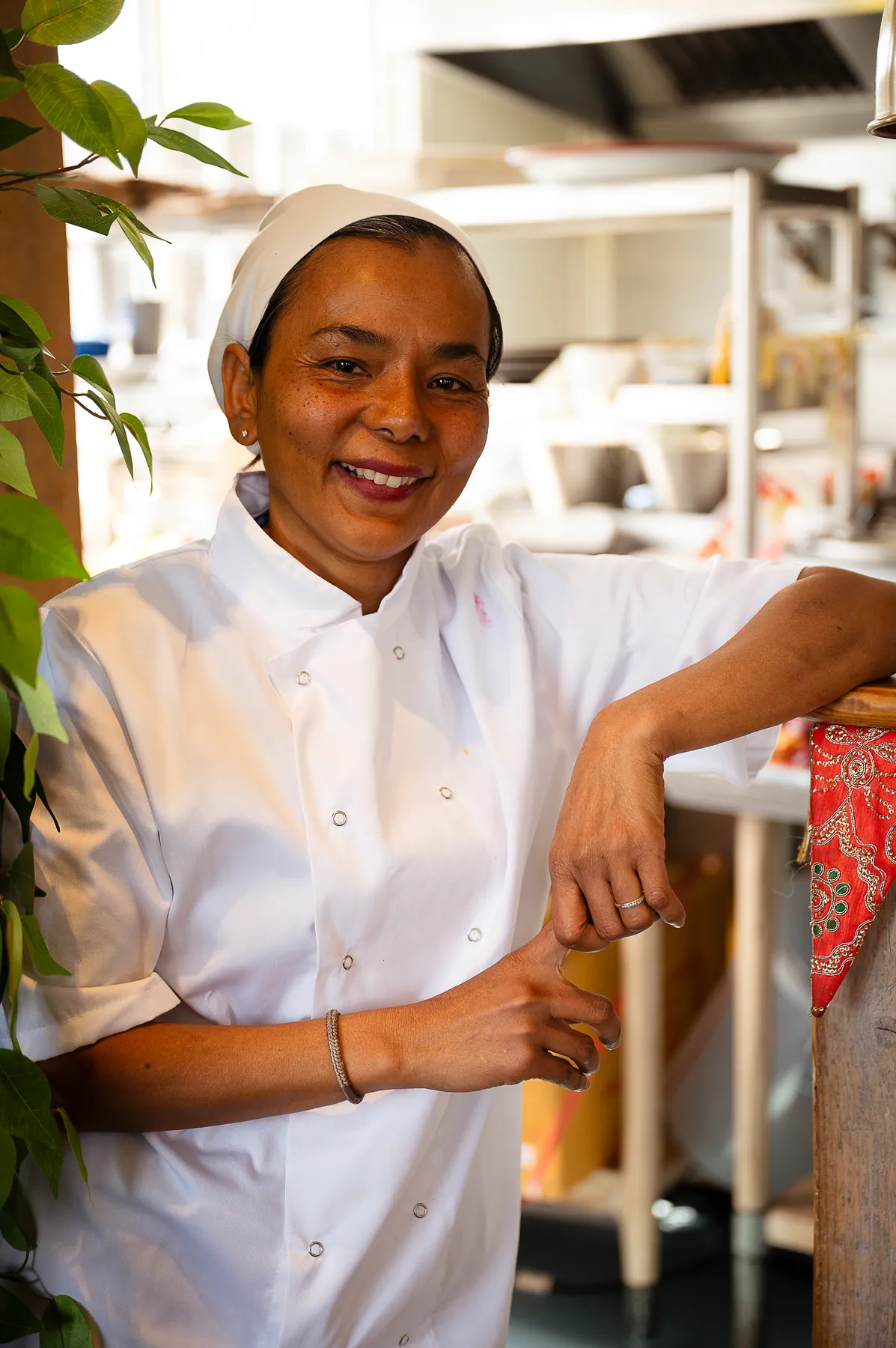 A chef in whites smiling in the kitchen