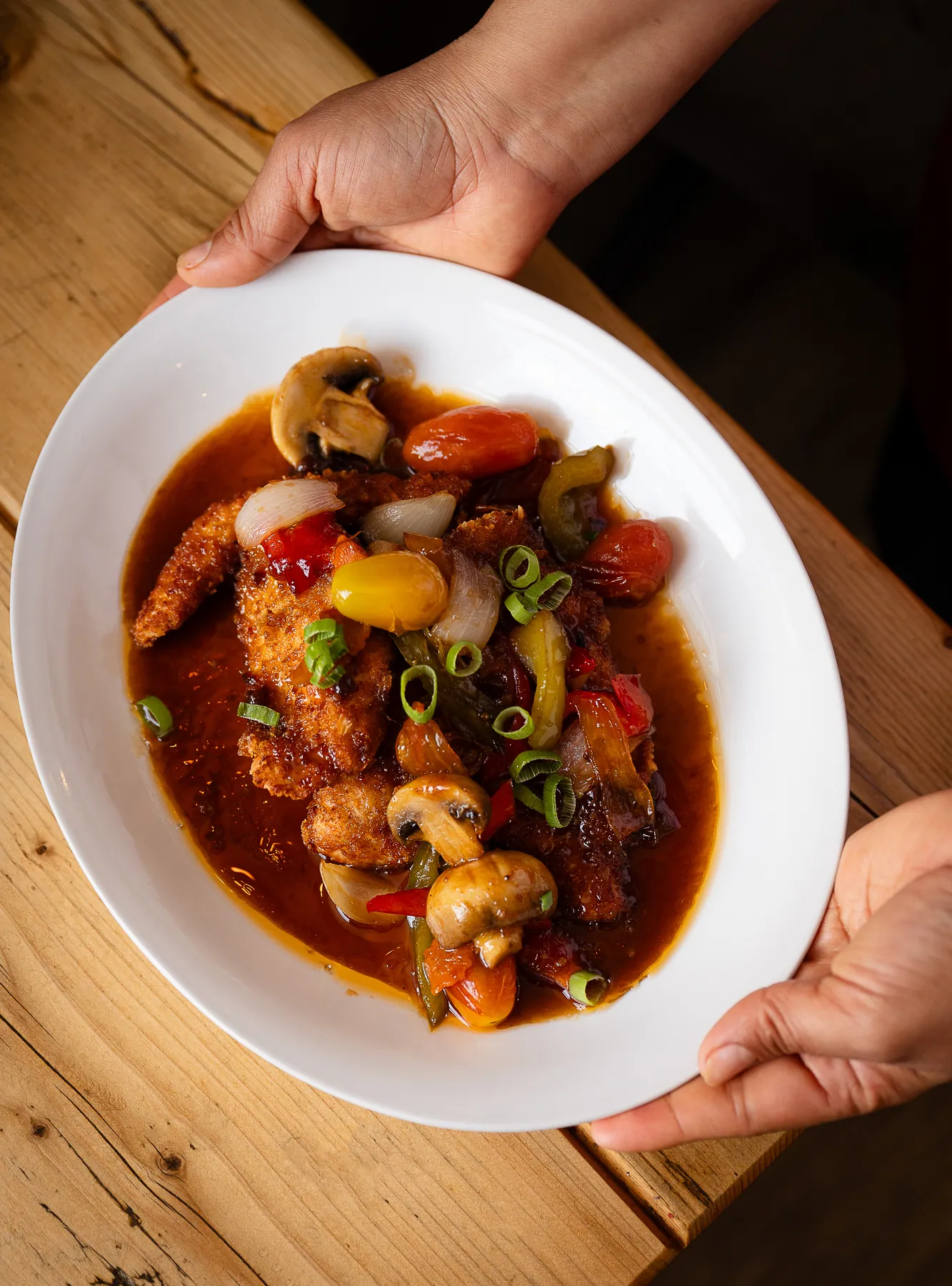 A bowl of Thai red curry being carried to the table