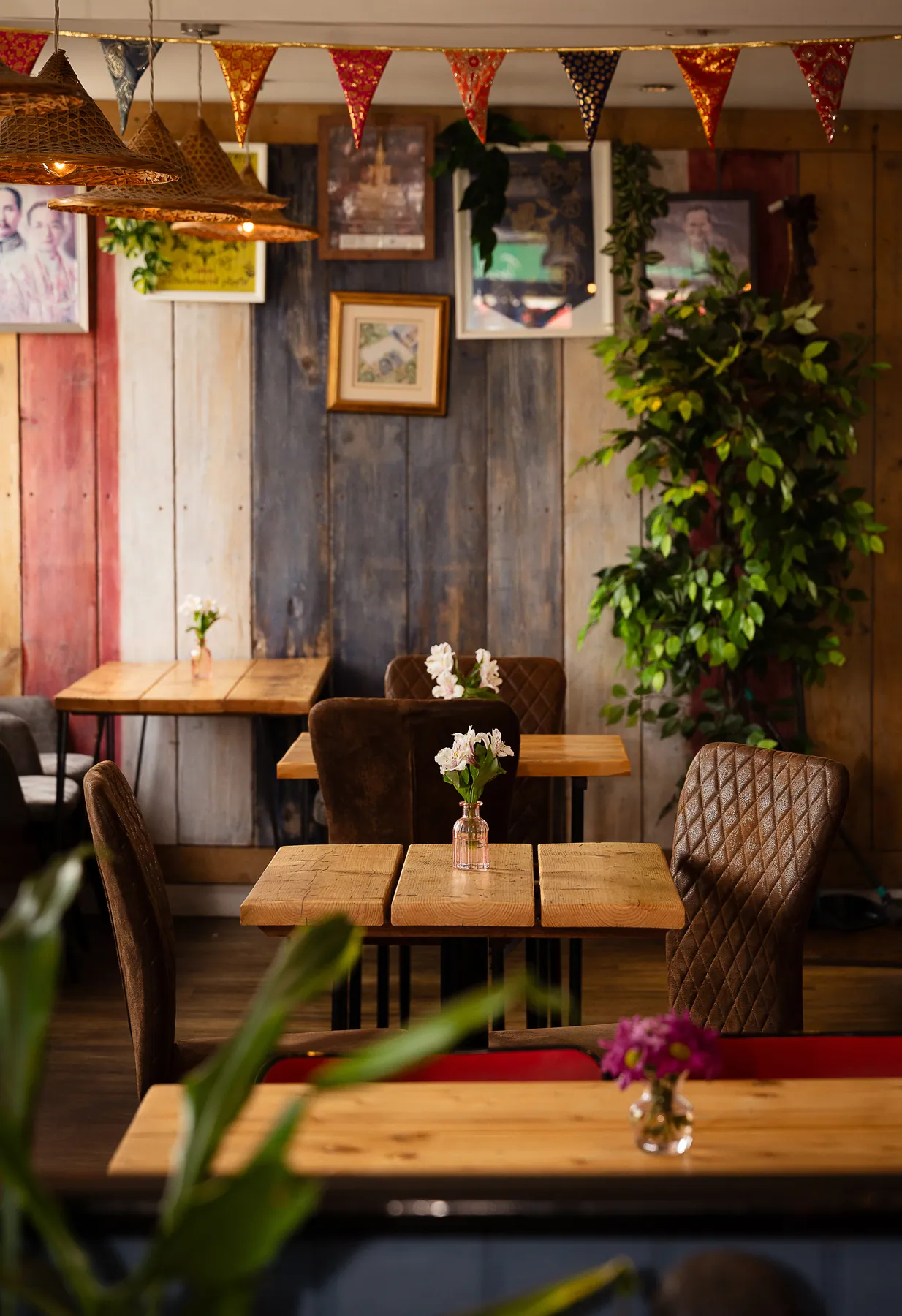 The Tiny Thai dining room with Thai bunting above reclaimed timber walls