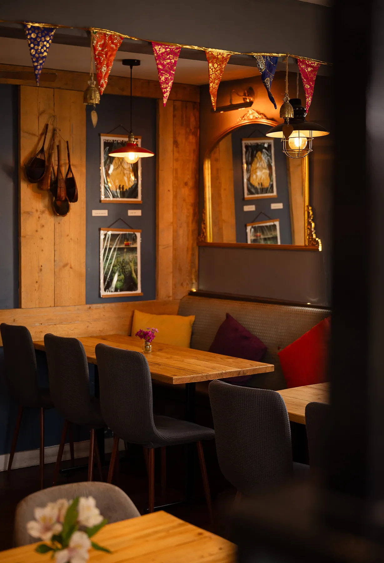 Wooden tables and velvet chairs under warm pendant lighting in the Wadebridge dining room