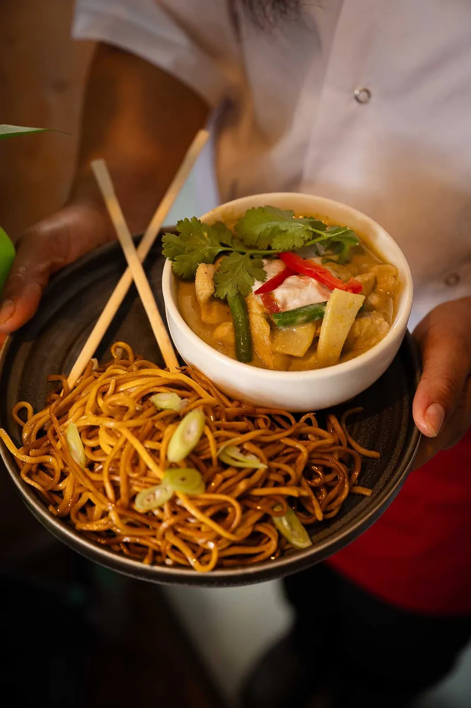 Thai green curry and noodles being served