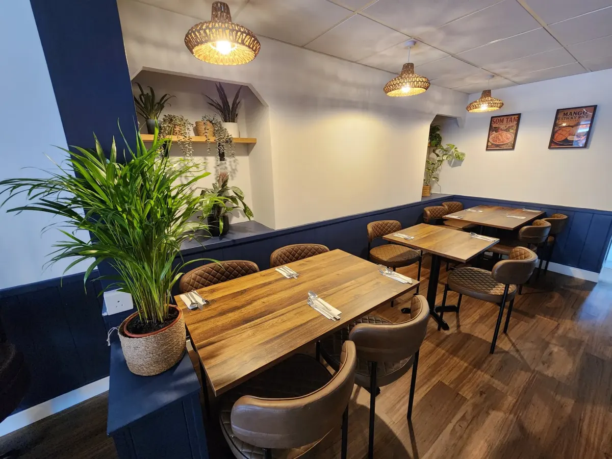 The Newquay dining room on East Street: navy walls, rattan lamps and wooden tables