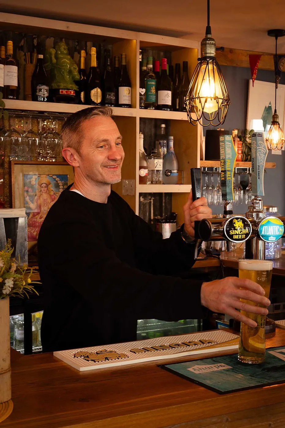 A pint being poured behind the bar at The Tiny Thai