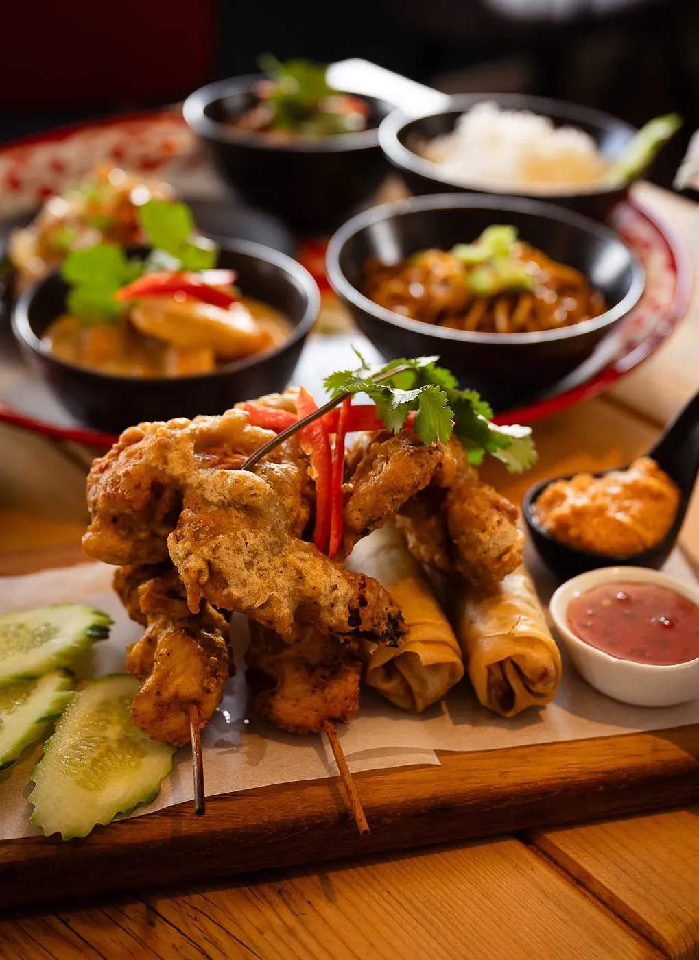 A Thai banquet of satay chicken, spring rolls, chicken wings and curries