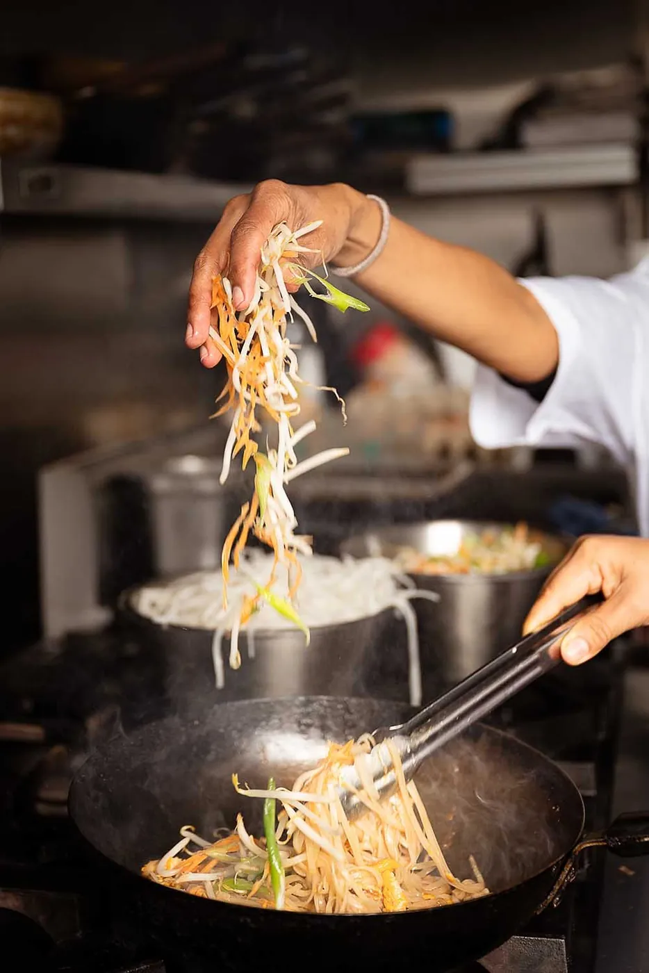 Bean sprouts being tossed into a hot wok